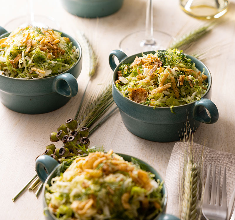 Individual dishes of brussel sprouts and wine.