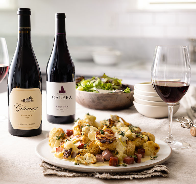 Wine and a plate of cauliflower are displayed on the kitchen counter