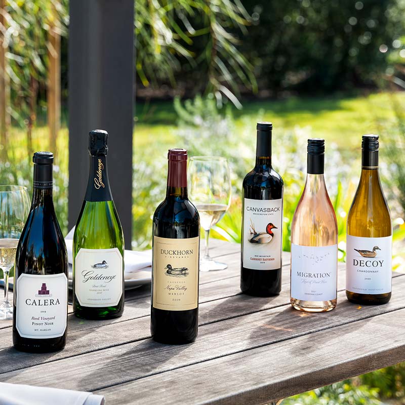Six bottles of Duckhorn Portfolio wines on an outdoor table
