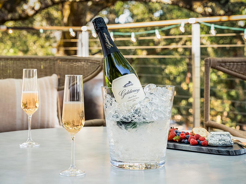 Goldeneye Sparkling Wine on outdoor patio with glasses and cheese