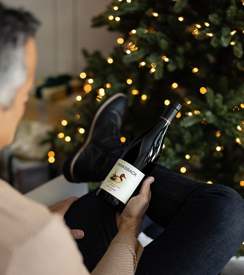 A man holding a Canvasback Syrah