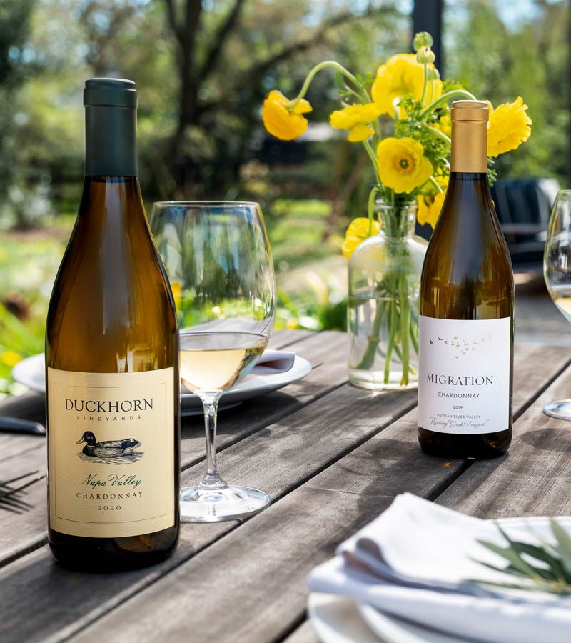 Two bottles of Duckhorn Portfolio Chardonnay on an outdoor table