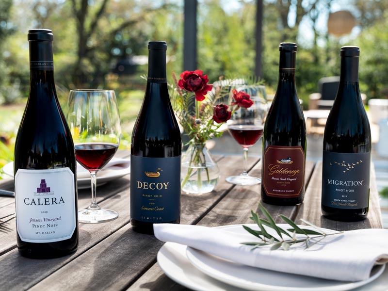Four bottles of Duckhorn Portfolio Pinot Noir on an outdoor table