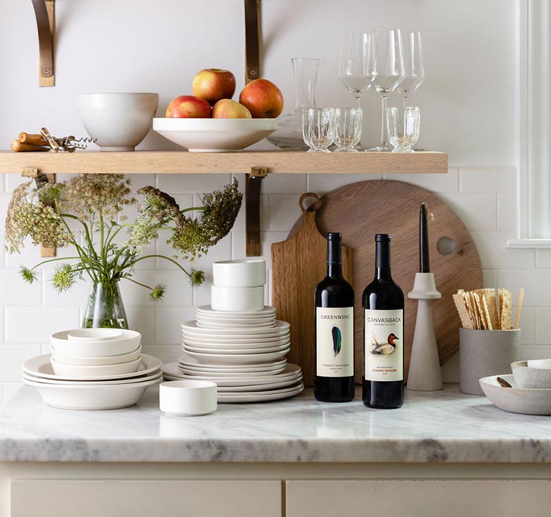 Two bottles of Duckhorn Portfolio Cabernet Sauvignon on a kitchen counter