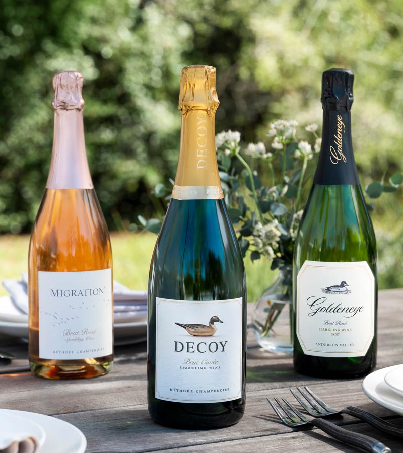 Three bottles of Duckhorn Portfolio Sparkling wine on an outdoor table