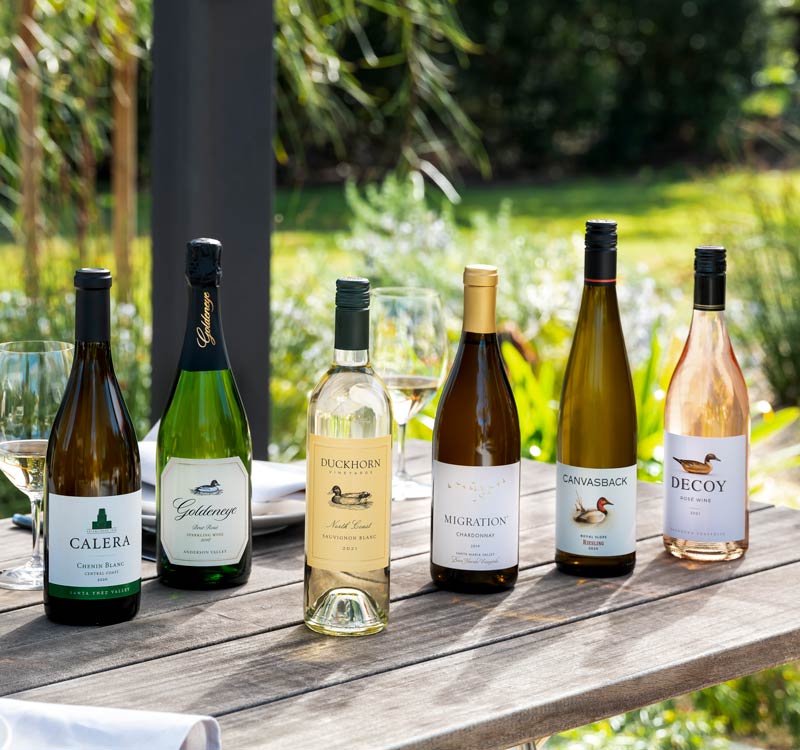Six bottles of Duckhorn Portfolio White wine and Rose on an outdoor table