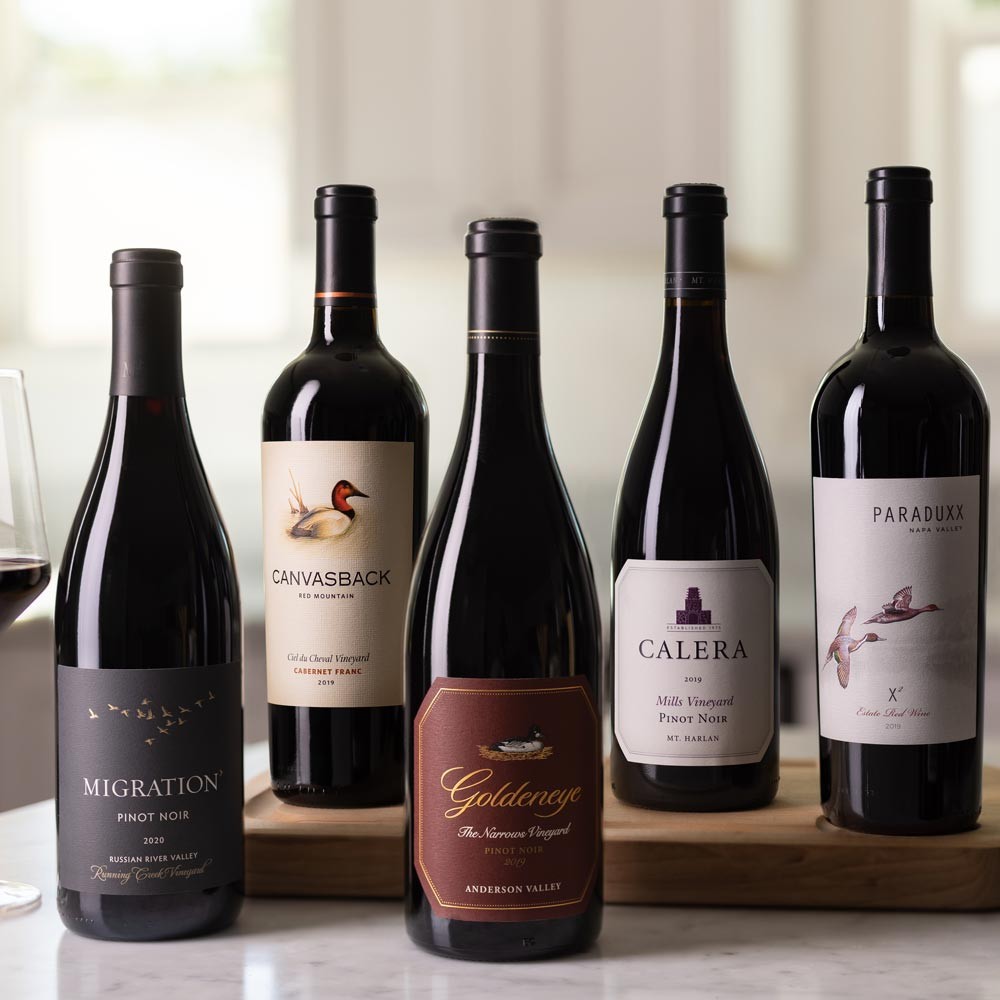 Six wines from The Duckhorn Portfolio on a counter with wine glasses